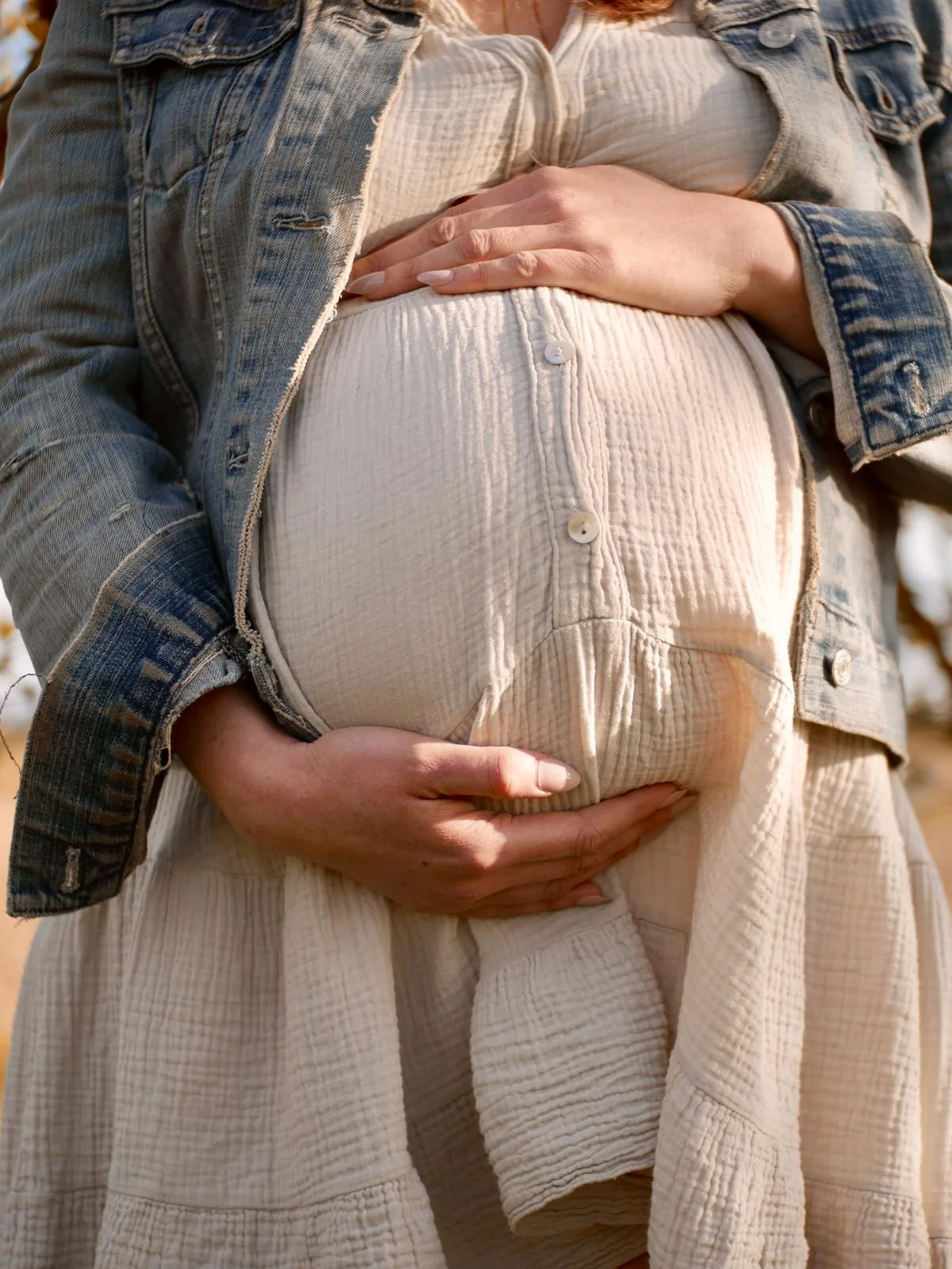 Tabea hält während ihrer Schwangerschaft behutsam ihren Bauch